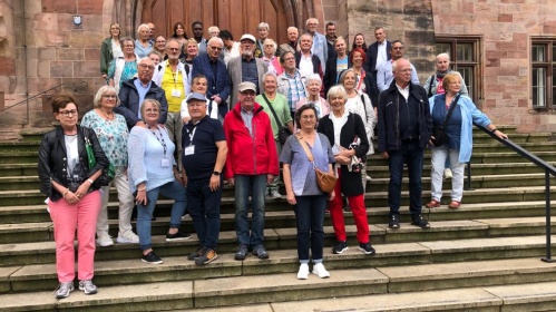 Eine Gruppe von Senioren steht vor der Basilika in Saarbrücken