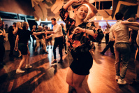 Ein Pärchen tanzt auf einer Tanzfläche voller Swingtänzern